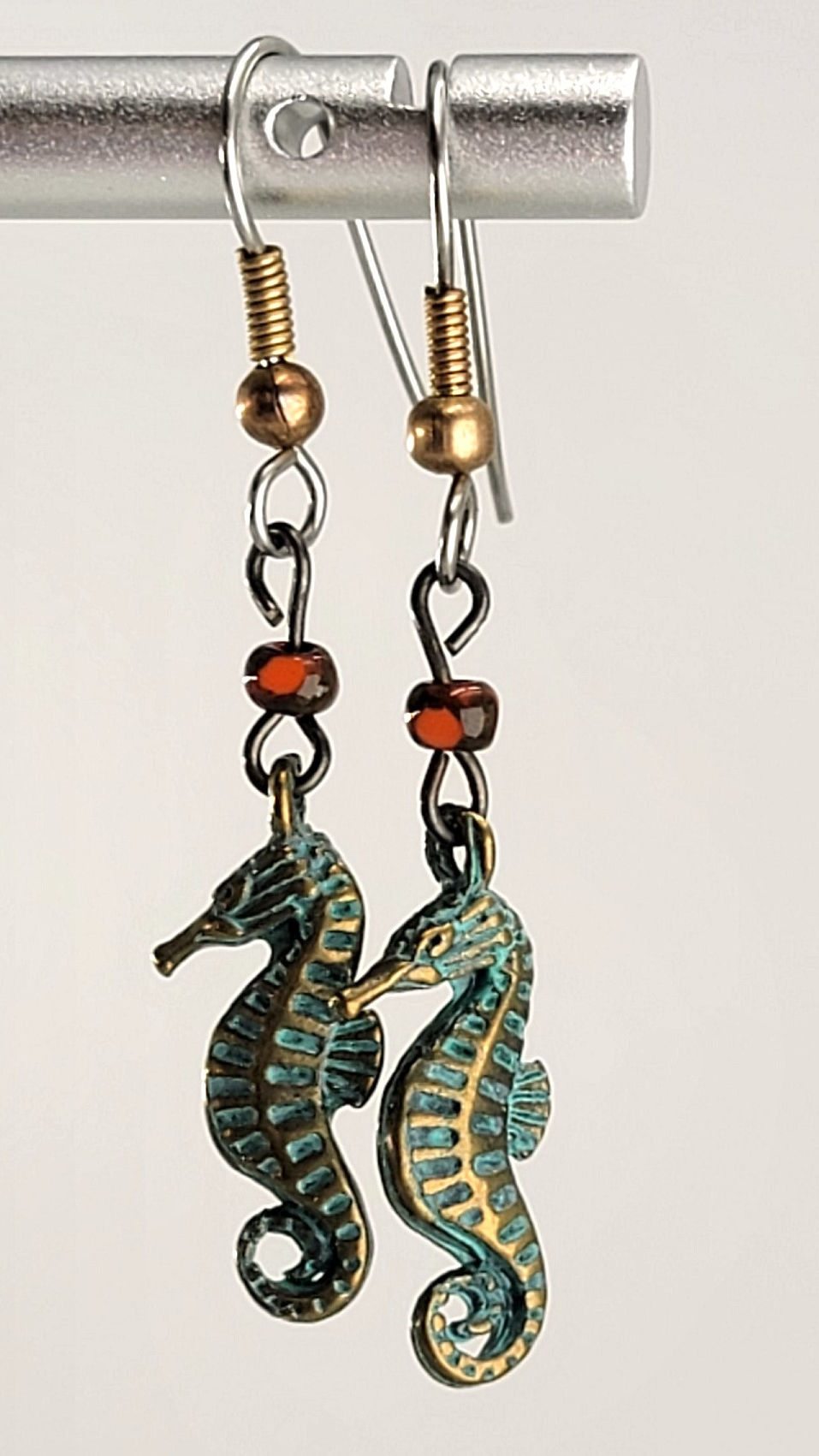 Handmade, hypoallergenic earrings with tiny green seahorses and red Picasso glass beads