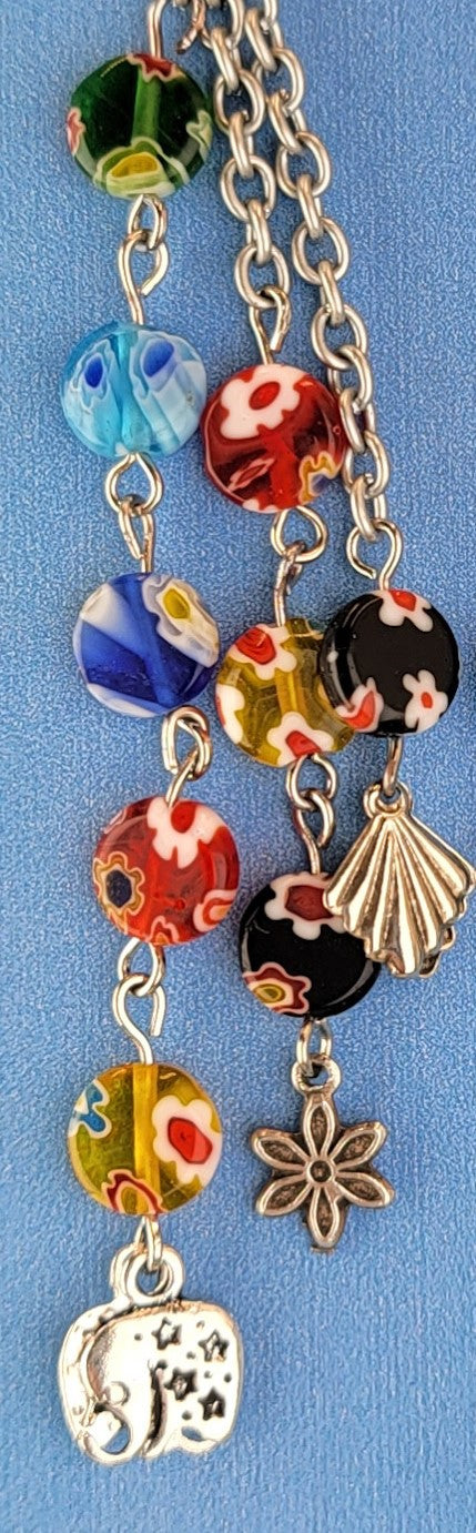 These handmade Boho earrings have African glass flower beads in a variety of colors and designs, along with an eclectic mix of pewter and antiqued silver charms. The ear wires are hypoallergenic surgical steel. Total earring length is 4".