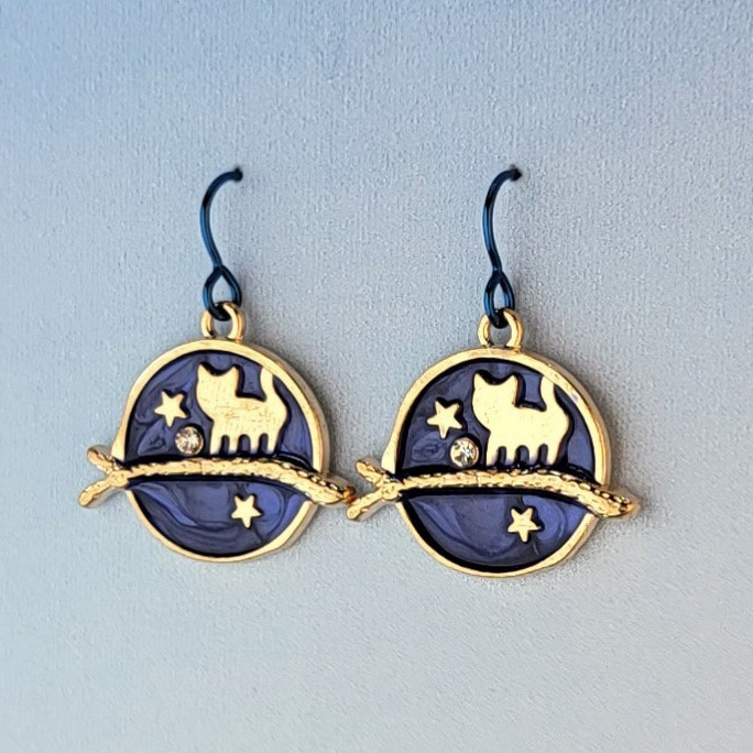 Hypoallergenic handmade cat earrings including gold cat on a branch with blue enamel background and stars