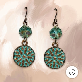 A sunburst medallion washed in verdigris patina hangs beneath a faceted aqua Picasso glass bead, all on hypoallergenic niobium hooks. They’re earthy, a little old-world, and easy to wear every day. 1 5/8" long.