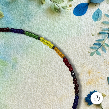 Detail view of a Pride rainbow beaded bracelet against a textured background with painted flowers