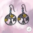 Handmade golden daisy earrings featuring silver-tone botanical branches, blue bead accents, and hypoallergenic niobium ear wires