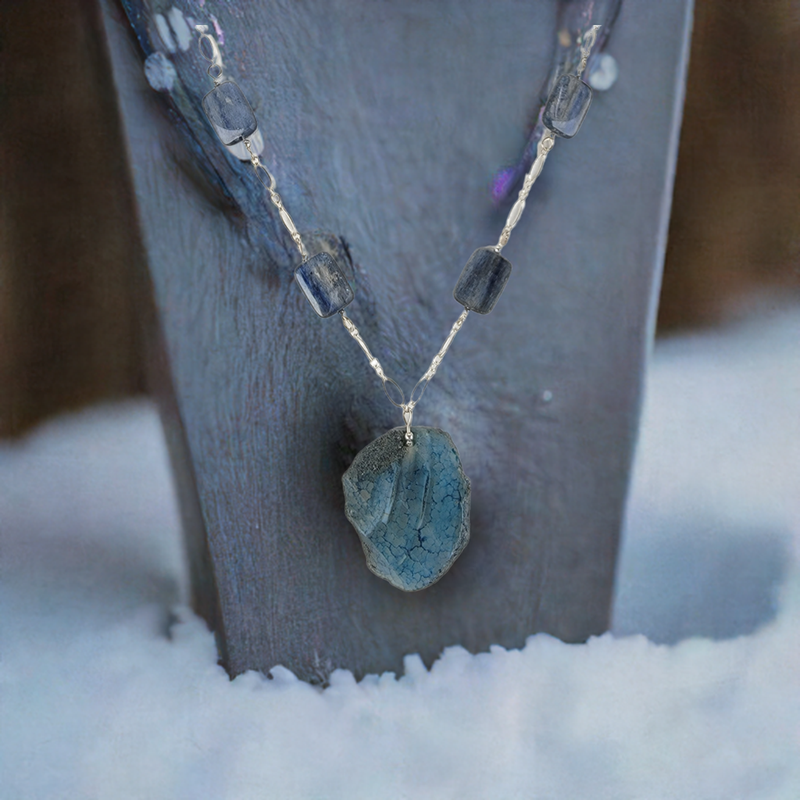 A necklace with a rough-cut blue kyanite pendant and sterling chain