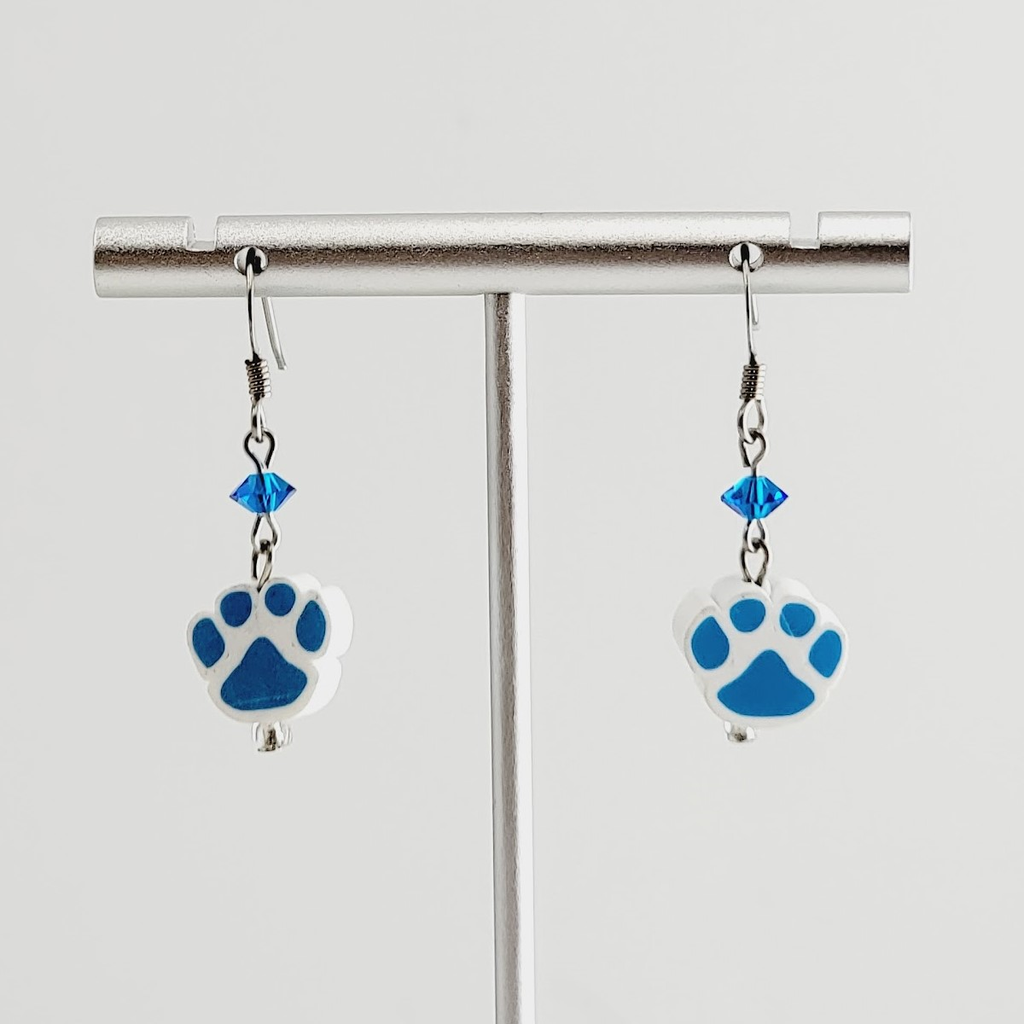 Handmade, hypoallergenic earrings with cobalt blue paw prints on white polymer clay and accented with cobalt blue crystals 