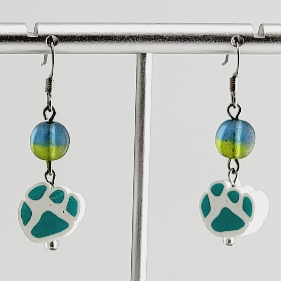 Handmade, hypoallergenic earrings with turquoise paw prints on white clay and accented with blue and green Czech glass beads 