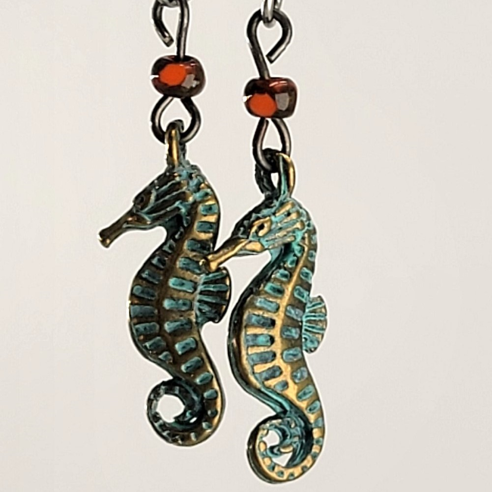 Handmade, hypoallergenic earrings with tiny green seahorses and red Picasso glass beads