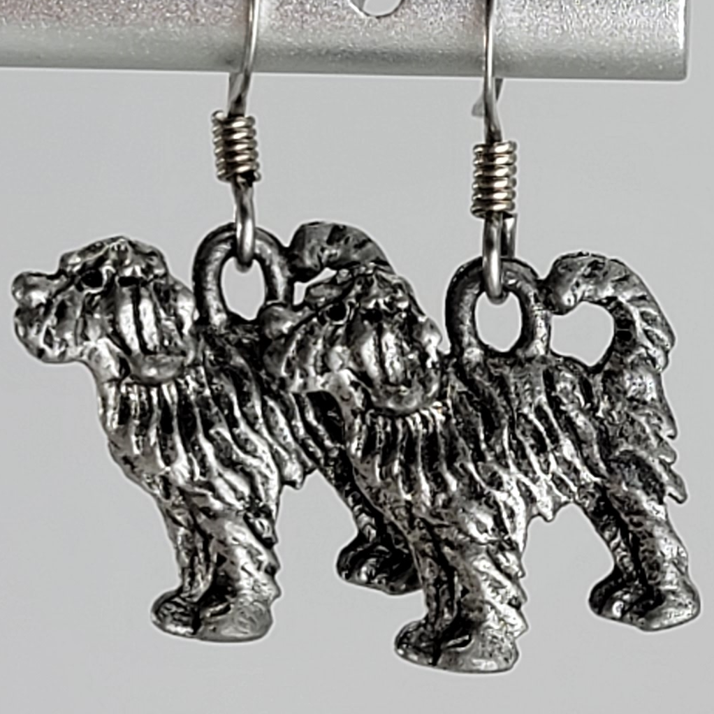Earrings, silver tone long haired dog, standing, with a curled tail. Ear wires are silver tone.