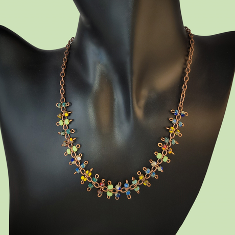 Brightly colored necklace with Picasso glass in greens, yellows, blues, and reds. Each station is a figure eight with bead at either end.