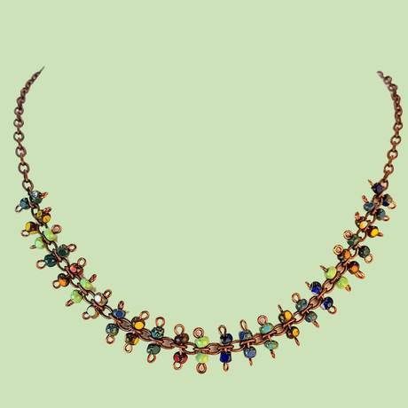 Brightly colored necklace with Picasso glass in greens, yellows, blues, and reds. Each station is a figure eight with bead at either end.