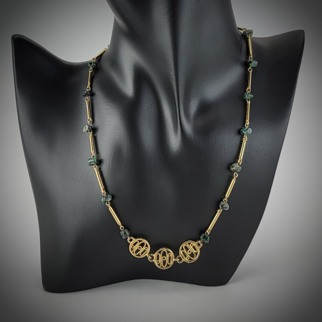 Handmade necklace with small emerald nuggets and gold tone chain and medallions