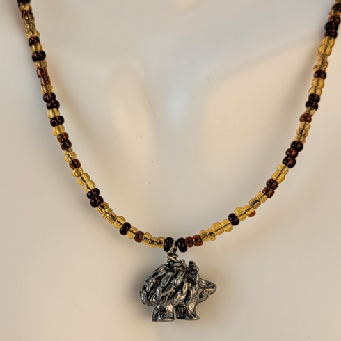 Handmade beaded necklace with brown and amber beads and a pewter hedgehog pendant