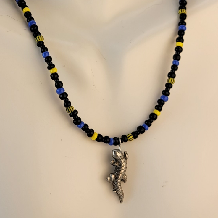 Handmade unisex necklace with a pewter lizard pendant, and beads in yellow, black, and blue