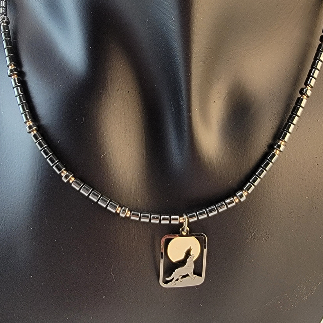Handmade necklace with pendant of a wolf howling at the moon and hematite and small gold filled beads