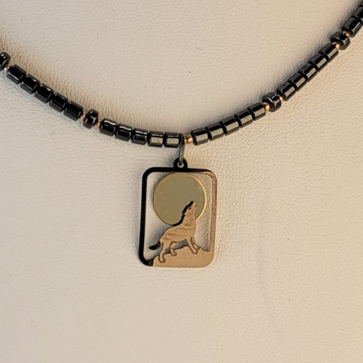 Handmade necklace with pendant of a wolf howling at the moon and hematite and small gold filled beads