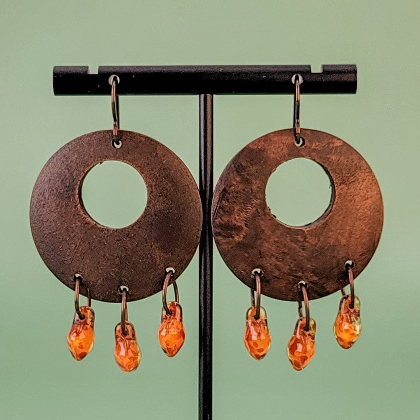 Handmade Boho earrings with amber colored Picasso glass dangling from rich brown wooden pendants. Ear wires are hypoallergenic niobium. Total earring length is 2 1/4".