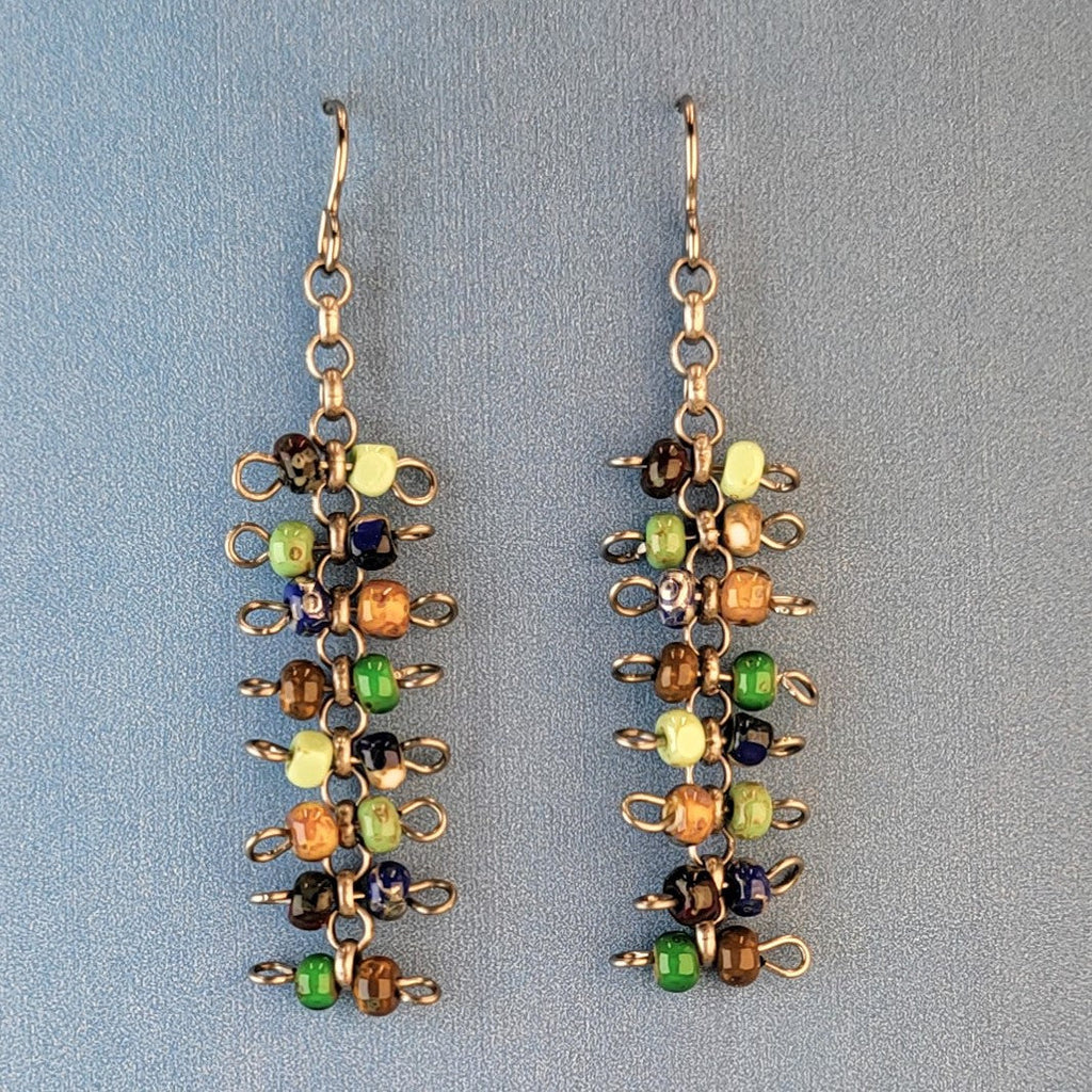 Handmade quirky Boho earrings with eight layers of colorful Picasso glass bead barbells. Hypoallergenic niobium ear wires. Total earring length is 2 3/8".