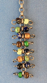 Handmade quirky Boho earrings with eight layers of colorful Picasso glass bead barbells. Hypoallergenic niobium ear wires. Total earring length is 2 3/8".