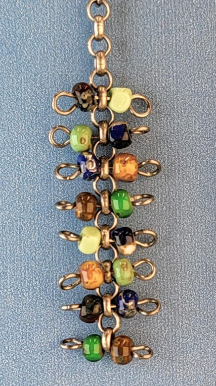 Handmade quirky Boho earrings with eight layers of colorful Picasso glass bead barbells. Hypoallergenic niobium ear wires. Total earring length is 2 3/8".