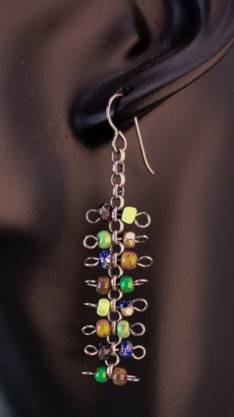 Handmade quirky Boho earrings with eight layers of colorful Picasso glass bead barbells. Hypoallergenic niobium ear wires. Total earring length is 2 3/8".