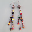 Long, dangly, colorful Boho earrings featuring three drops filled with richly-colored Picasso glass beads and silver-colored accents. 