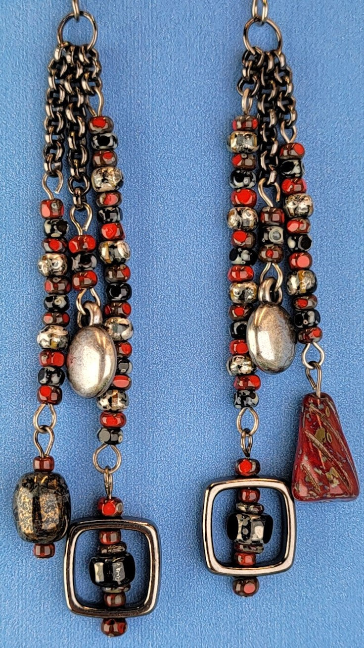 Handmade Boho style earrings with a retro feel. Red, black, and gray Picasso glass along with a bit of pewter, and gleaming black square frames. These beauties are 3 1/2" long with hypoallergenic niobium ear wires.