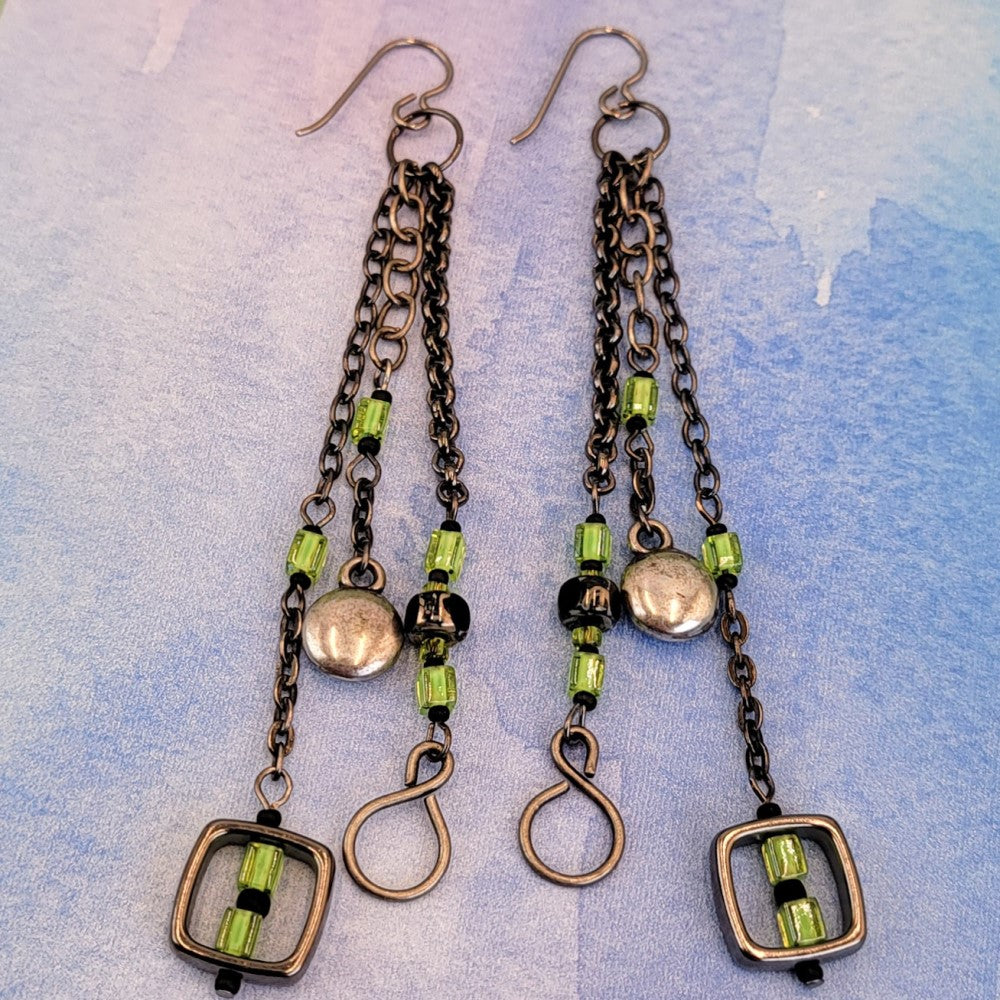 Handmade Boho earrings on gunmetal chain with bright green cubes and Picasso glass, metallic puff circles and hollow squares. 