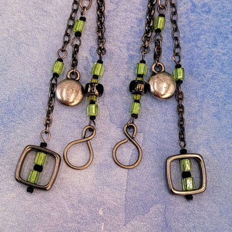 Handmade Boho earrings on gunmetal chain with bright green cubes and Picasso glass, metallic puff circles and hollow squares. 