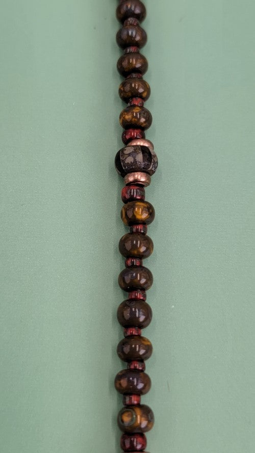 Handmade Boho necklace with rustic arrowhead and Picasso glass in rich browns and reds. 