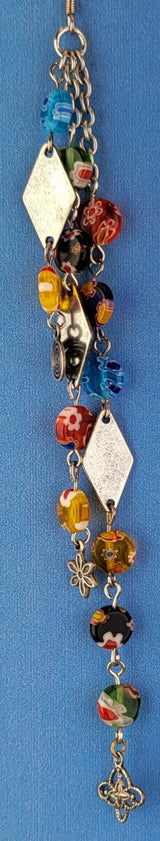 These handmade Boho earrings have African glass flower beads in a variety of colors and designs, along with an eclectic mix of pewter and antiqued silver charms. The ear wires are hypoallergenic surgical steel. Total earring length is 6".