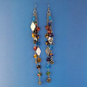 These handmade Boho earrings have African glass flower beads in a variety of colors and designs, along with an eclectic mix of pewter and antiqued silver charms. The ear wires are hypoallergenic surgical steel. Total earring length is 6".