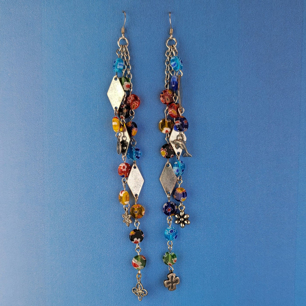 These handmade Boho earrings have African glass flower beads in a variety of colors and designs, along with an eclectic mix of pewter and antiqued silver charms. The ear wires are hypoallergenic surgical steel. Total earring length is 6".