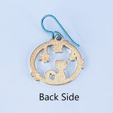 Handmade cat and star earrings including blue enamel cat on blue background looking at green enamel stars