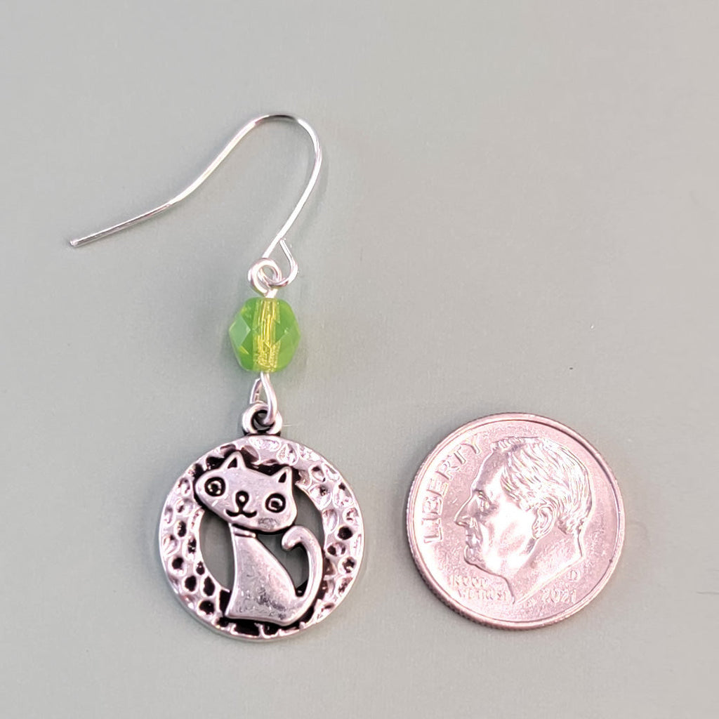 Hypoallergenic silver cat earrings have hammered silver rings with sweet smiling kittens and green Czech glass accent beads