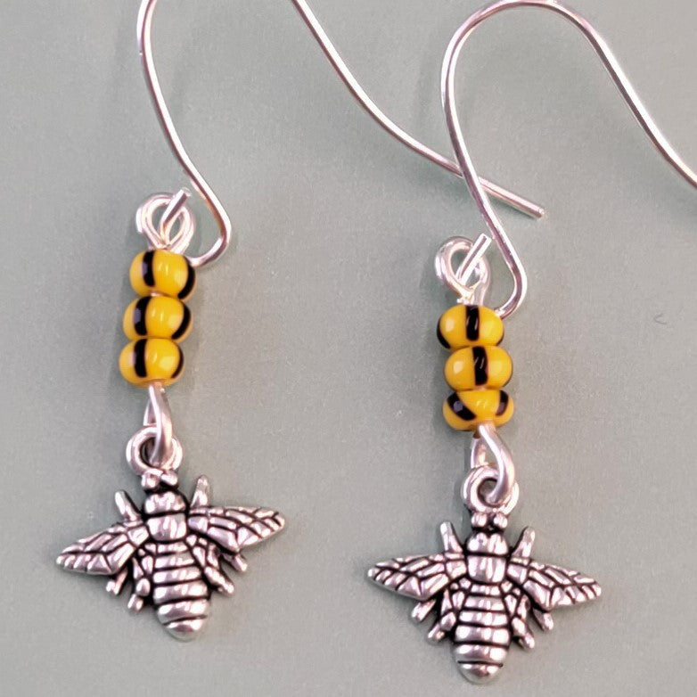 Handmade hypoallergenic bee earrings, each with three yellow and black glass beads