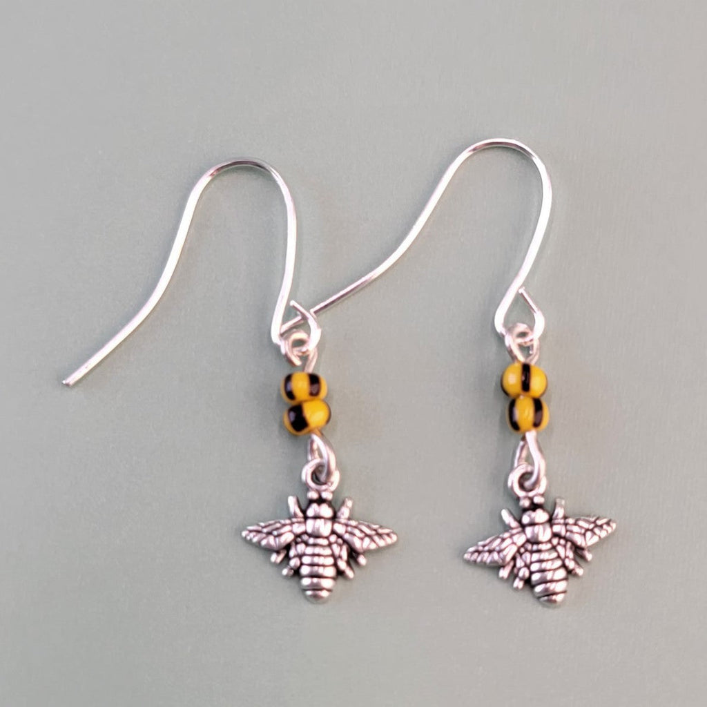 Handmade hypoallergenic bee earrings, each with two yellow and black glass beads