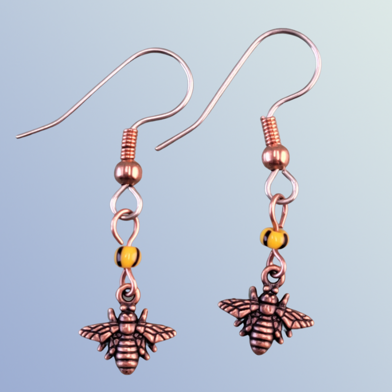 Handmade hypoallergenic copper bee earrings, each with yellow and black glass beads
