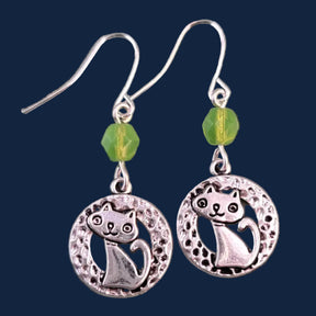Hypoallergenic silver cat earrings have hammered silver rings with sweet smiling kittens and green Czech glass accent beads